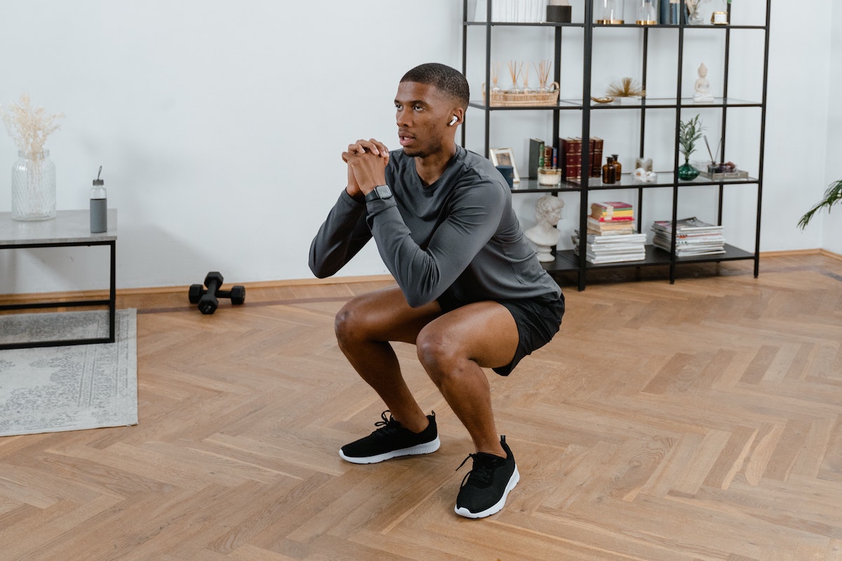 Man doing squats at home.